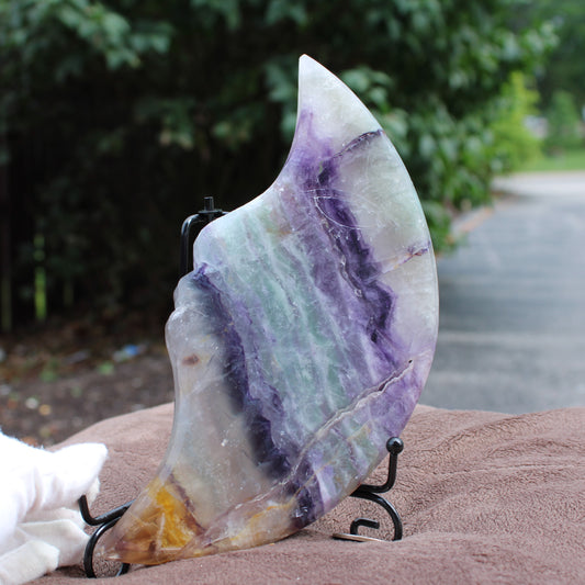 Rainbow Fluorite Cresent Moon Statement Crystal with purple and green bands on a black metal stand