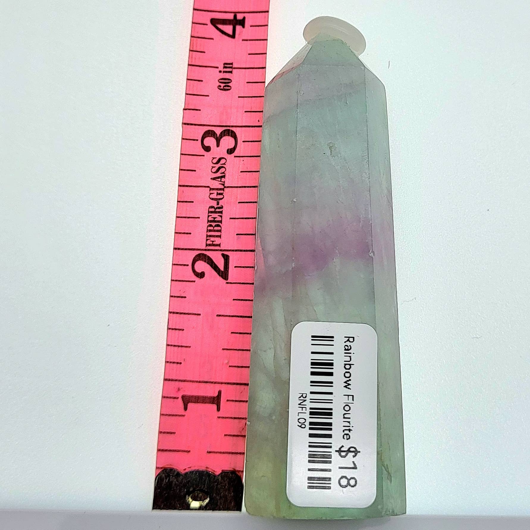 Rainbow fluorite tower with lavender and green hues displays unique crystal formations and a polished finish