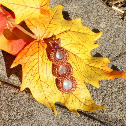 Rainbow moonstone copper pendant featuring three iridescent stones set in intricate copper design