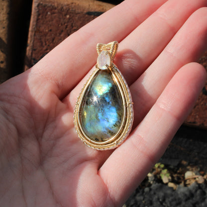 Rainbow Moonstone & Labradorite 14k Gold fill pendant elegantly displayed in a hand