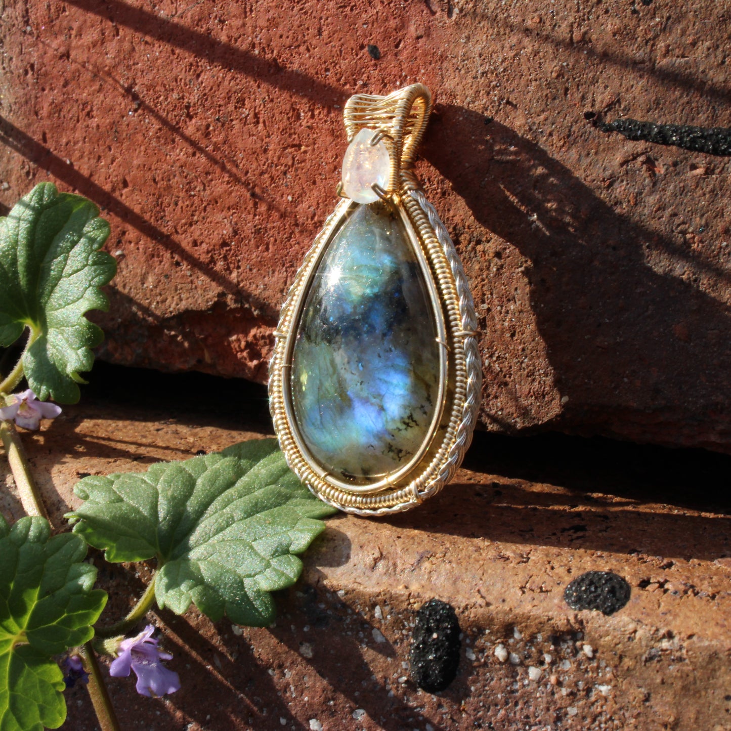 Rainbow Moonstone & Labradorite 14k Gold fill pendant elegantly displayed on textured stones