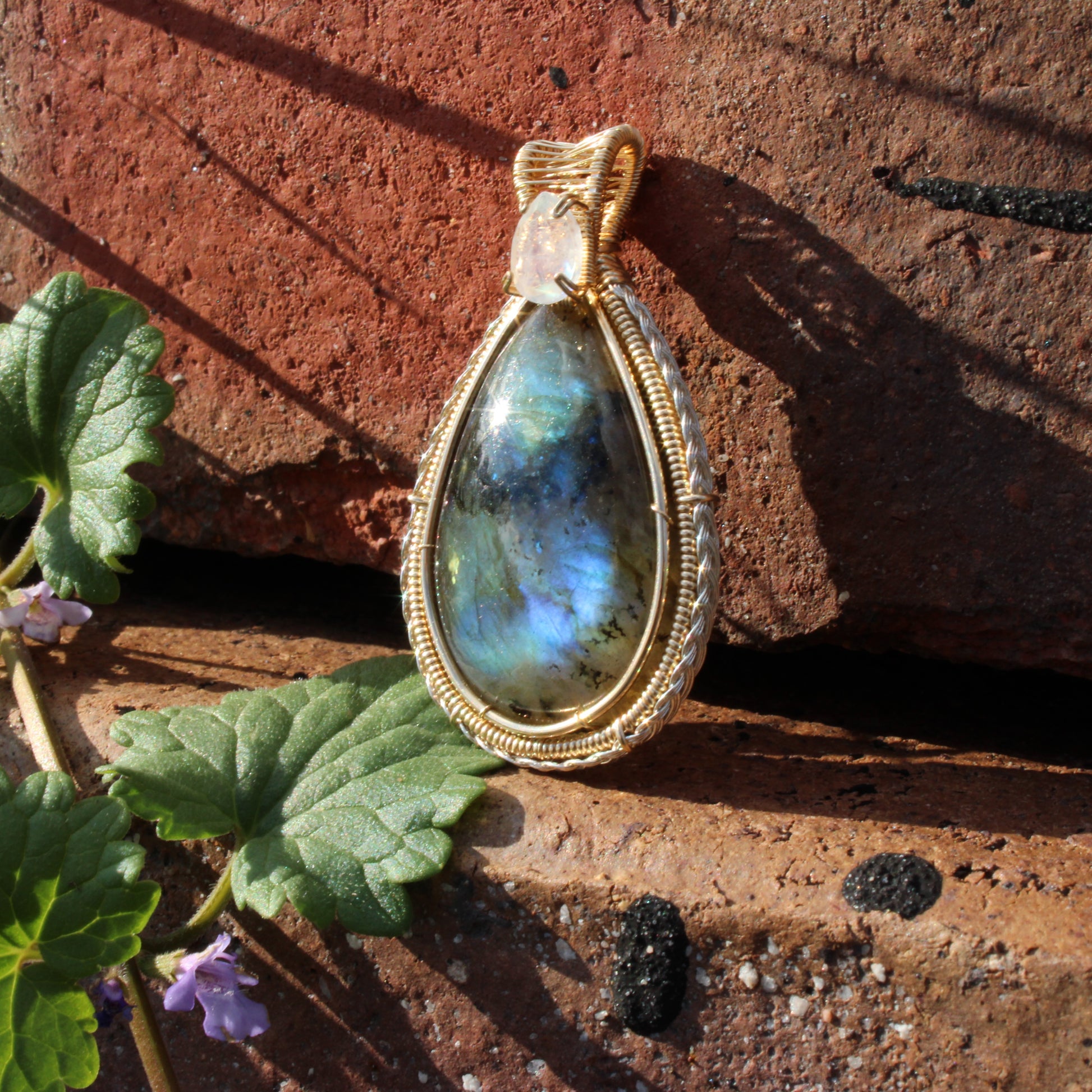 Rainbow Moonstone & Labradorite 14k Gold fill pendant elegantly displayed on textured stones