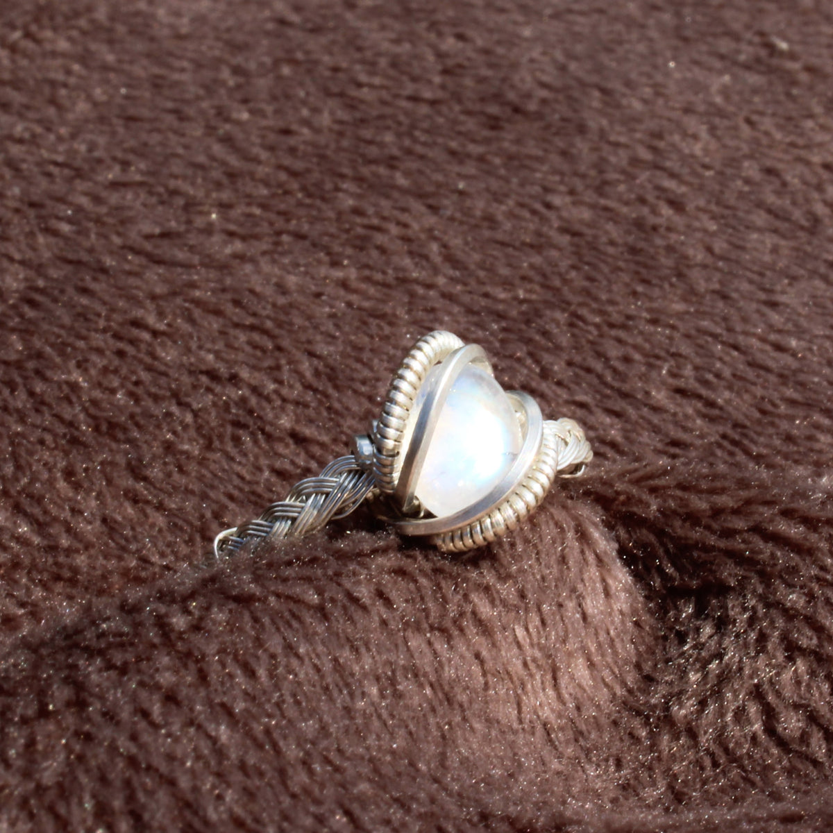 Rainbow Moonstone Sterling Ring featuring a unique twisted band and elegant stone setting