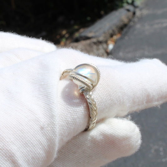 Rainbow Moonstone Sterling Ring on a hand with a white glove showcasing its unique design and luster