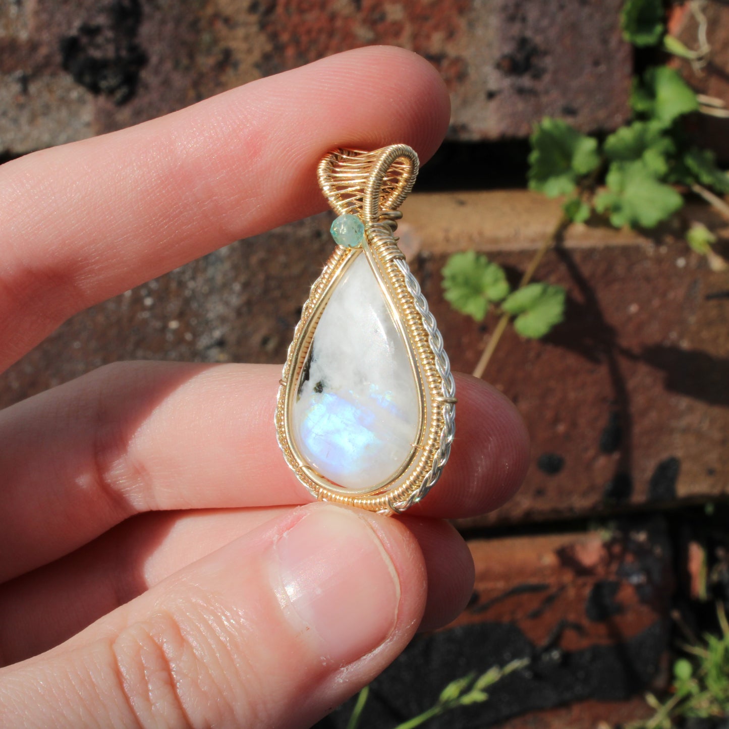 Rainbow moonstone Sterling Silver, 14k Gold Fill pendant with a unique teardrop design held between fingers