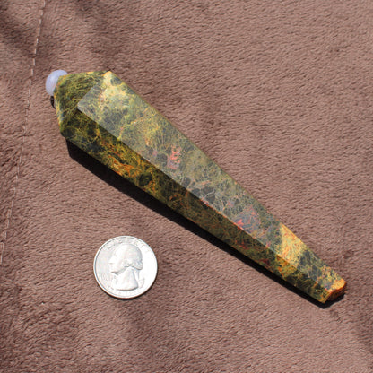 Realgar Wand crystal with mixed green and orange hues displayed next to a quarter for size comparison