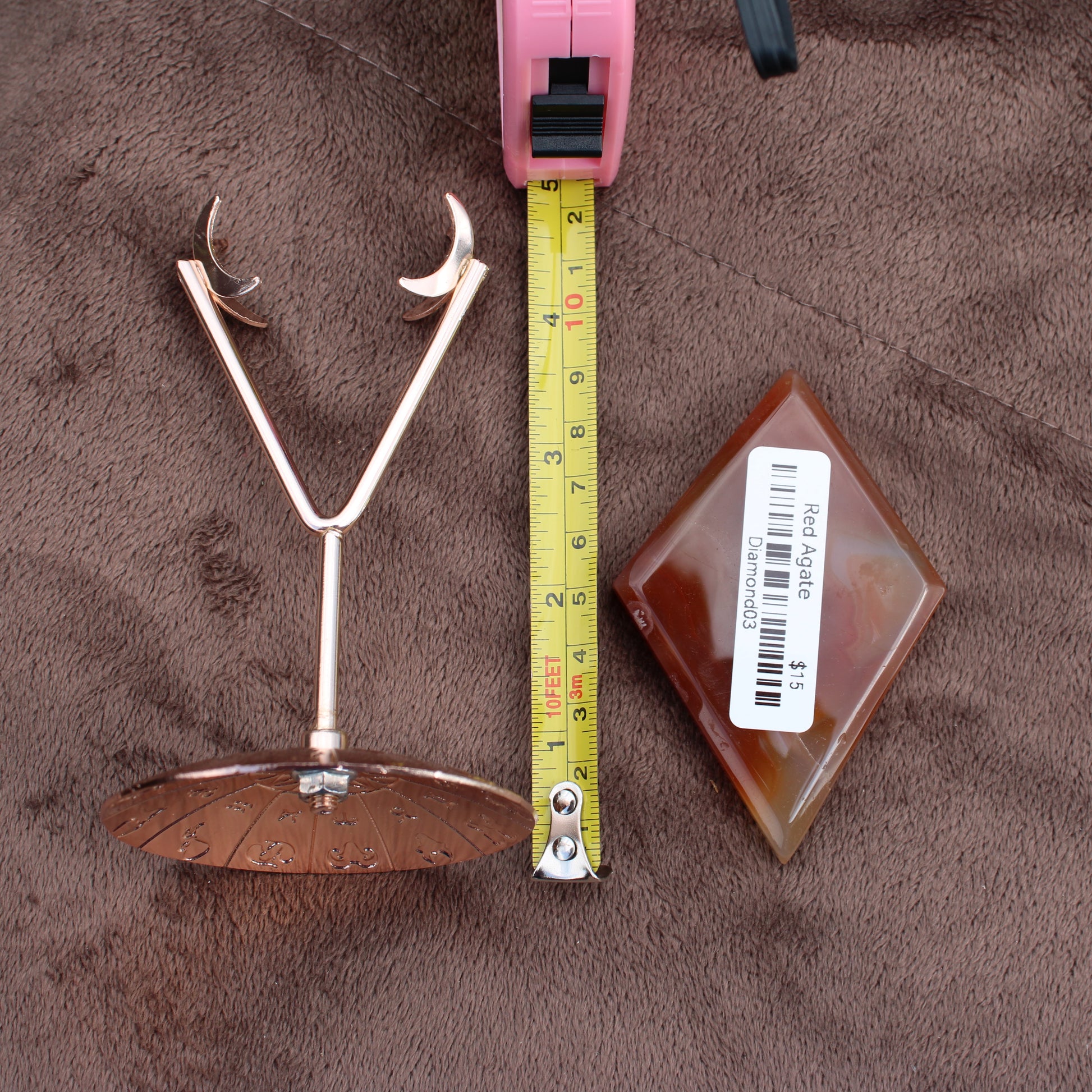 Red Agate Diamond crystal from Different Branches LLC displayed next to a tape measure and metal stand