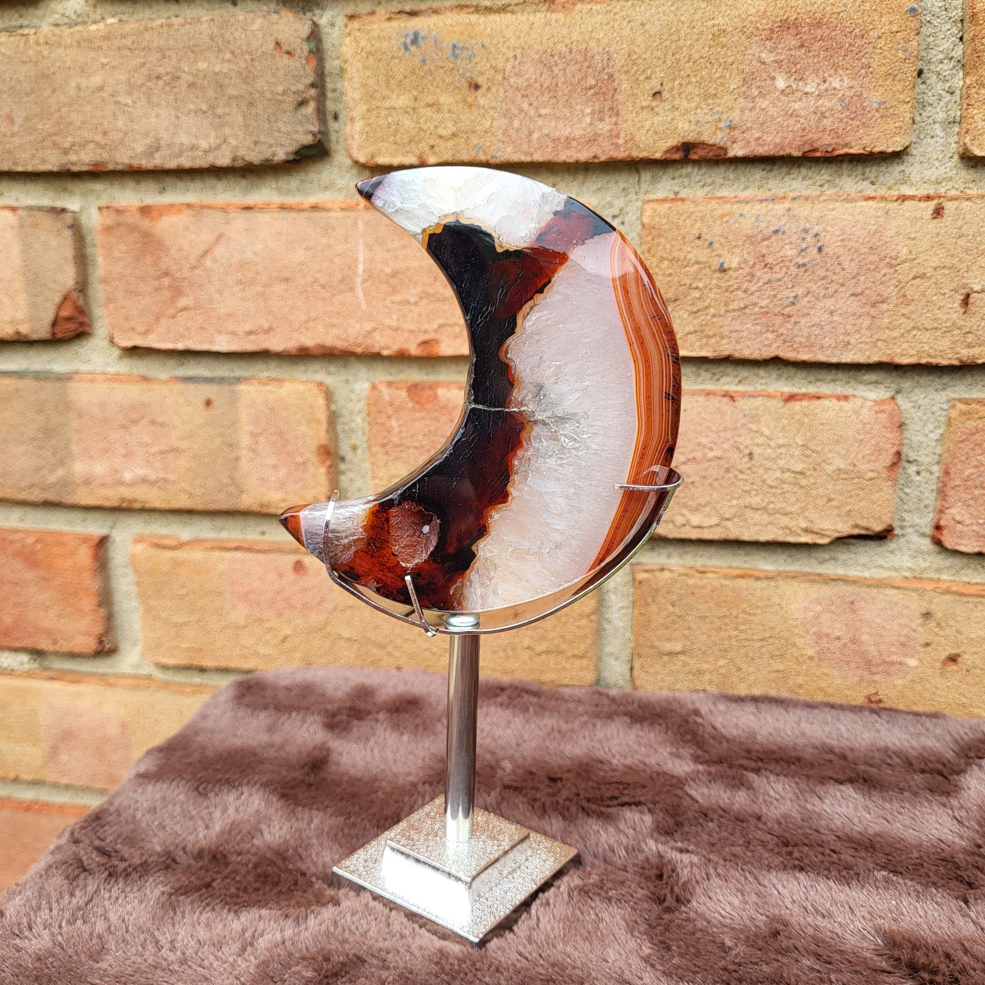 Red Agate Moon on a silver stand showcasing unique patterns and colors for home decor