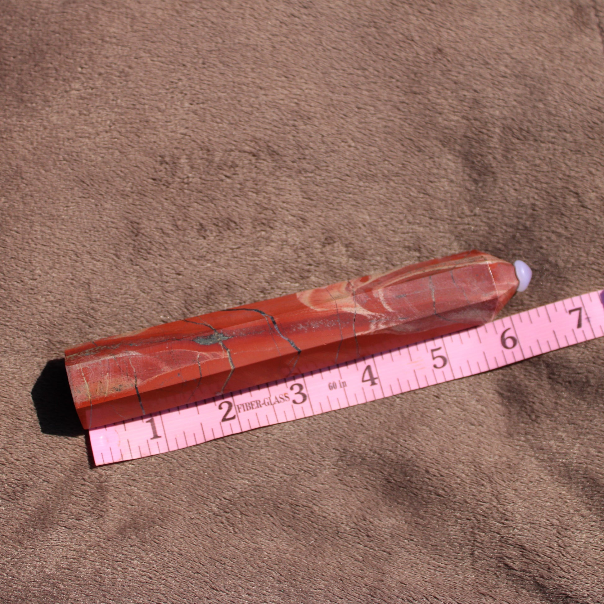 Red jasper tower with natural patterns, measuring approximately six inches in length