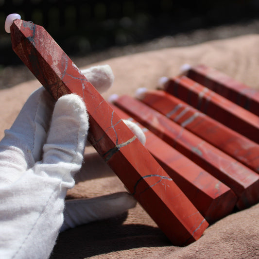 Handheld red jasper tower with polished surface, showcasing its vibrant color and unique patterns