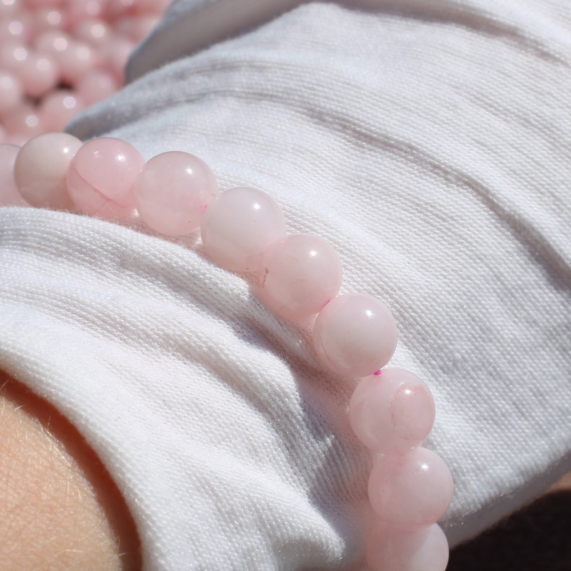 Close-up of a Rose Quartz Bracelet on a wrist, showcasing polished pink stones for healing energy