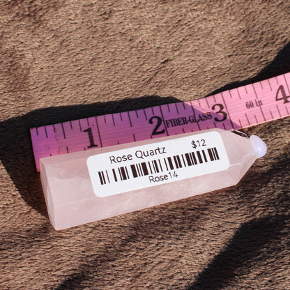 Rose Quartz tower displayed with a ruler for scale, showcasing its natural beauty and soft pink color