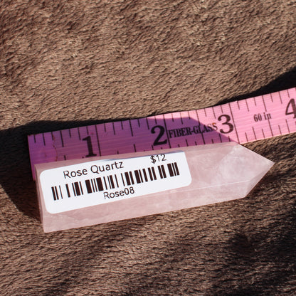 Polished Rose Quartz tower displayed alongside a measuring tape for size reference