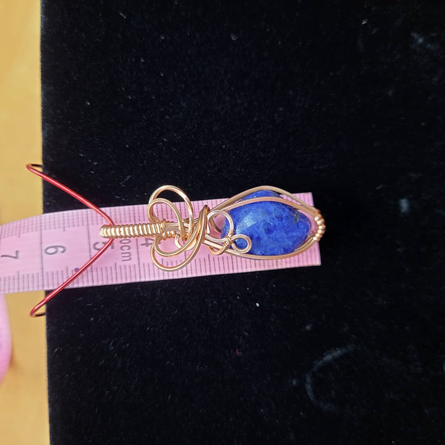 Unique Sodalite Pendant Wrapped in Gold Wire on a Black Velvet Display