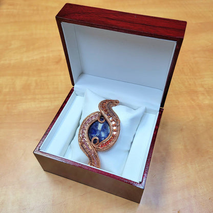 Sodalite raw copper bracelet displayed in elegant wooden jewelry box with soft white lining