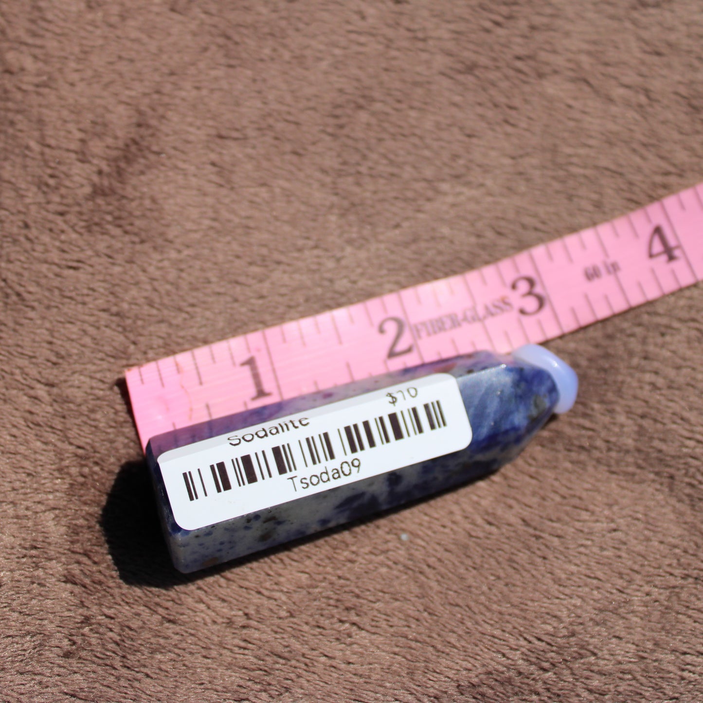 Sodalite tower from Different Branches LLC with a blue hue and measuring tape for scale