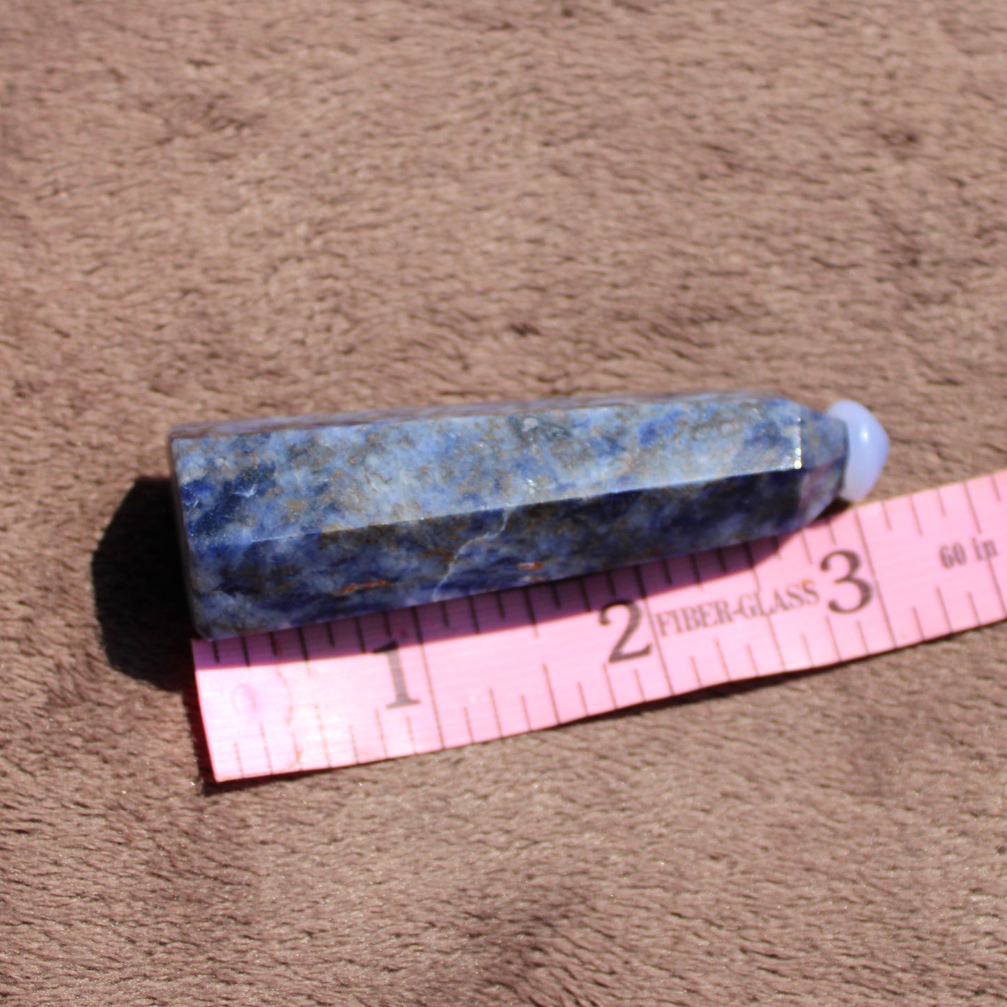 Natural Sodalite tower in blue hues with a smooth finish on a soft background