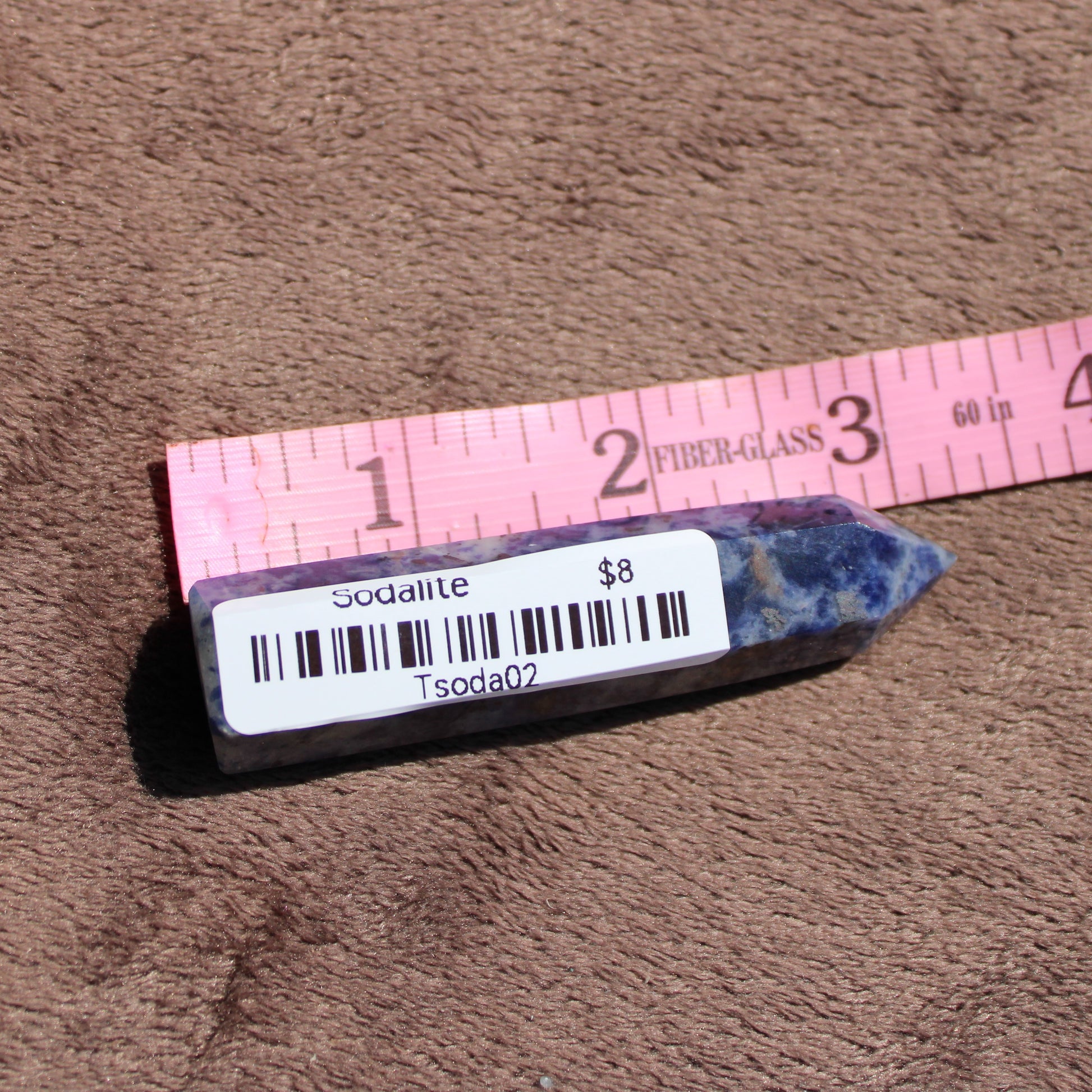 Sodalite tower gemstone showcasing deep blue hues with natural crystal formations and a price tag