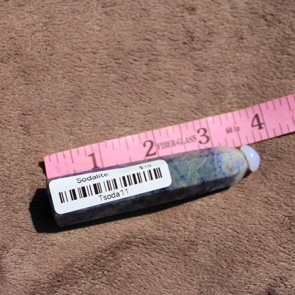 Sodalite tower crystal with a polished surface and purple-blue hues displayed alongside a ruler for size reference
