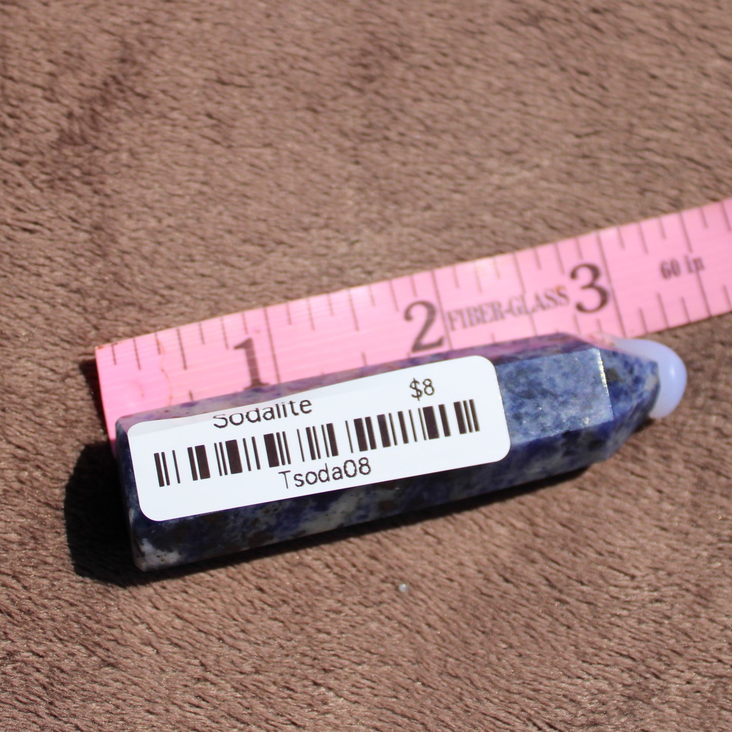 Sodalite tower crystal displayed with a ruler for size reference and price tag