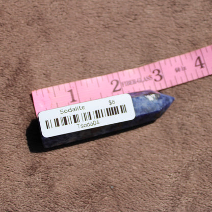 Sodalite tower with deep blue hues displayed next to a ruler for size comparison
