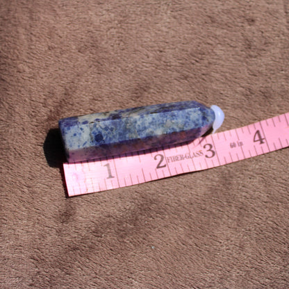 Sodalite tower from Different Branches LLC on beige fabric with a measuring tape for size reference
