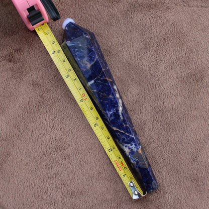 Sodalite Wand crystal measuring approximately 7 inches placed next to a yellow tape measure on brown fabric