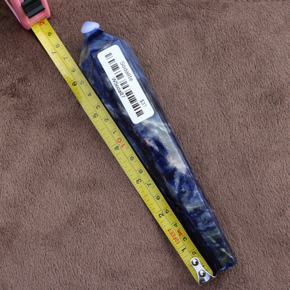 Sodalite Wand crystal from Different Branches LLC placed beside measuring tape showing length on brown background
