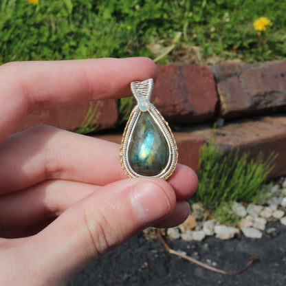 Sterling Silver Labradorite Ethiopian Opal Tear Drop Pendant held in hand, showcasing natural beauty and craftsmanship