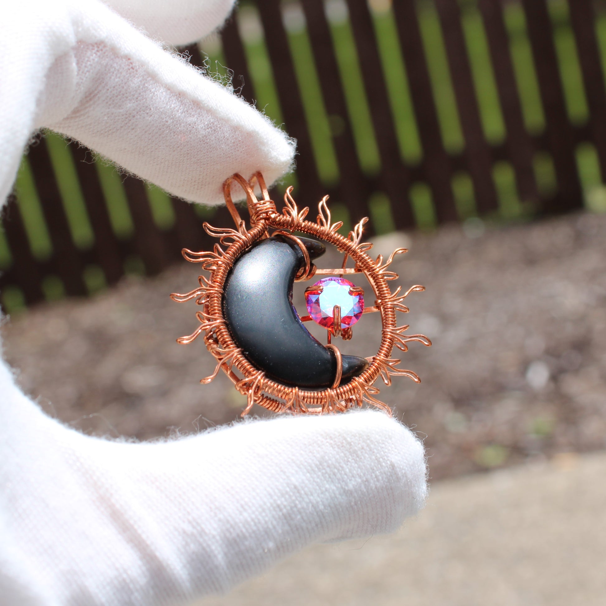 Sun and moon copper collection pendant featuring a black crescent moon and a colorful gemstone
