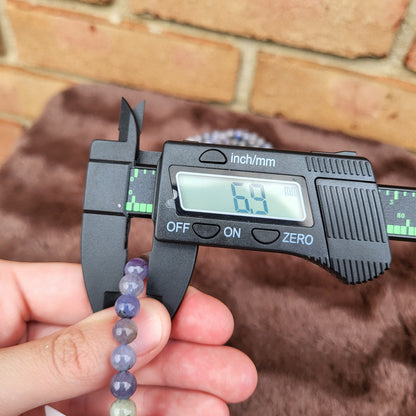 Measuring the size of a Tanzanite bracelet using a caliper for precise dimensions