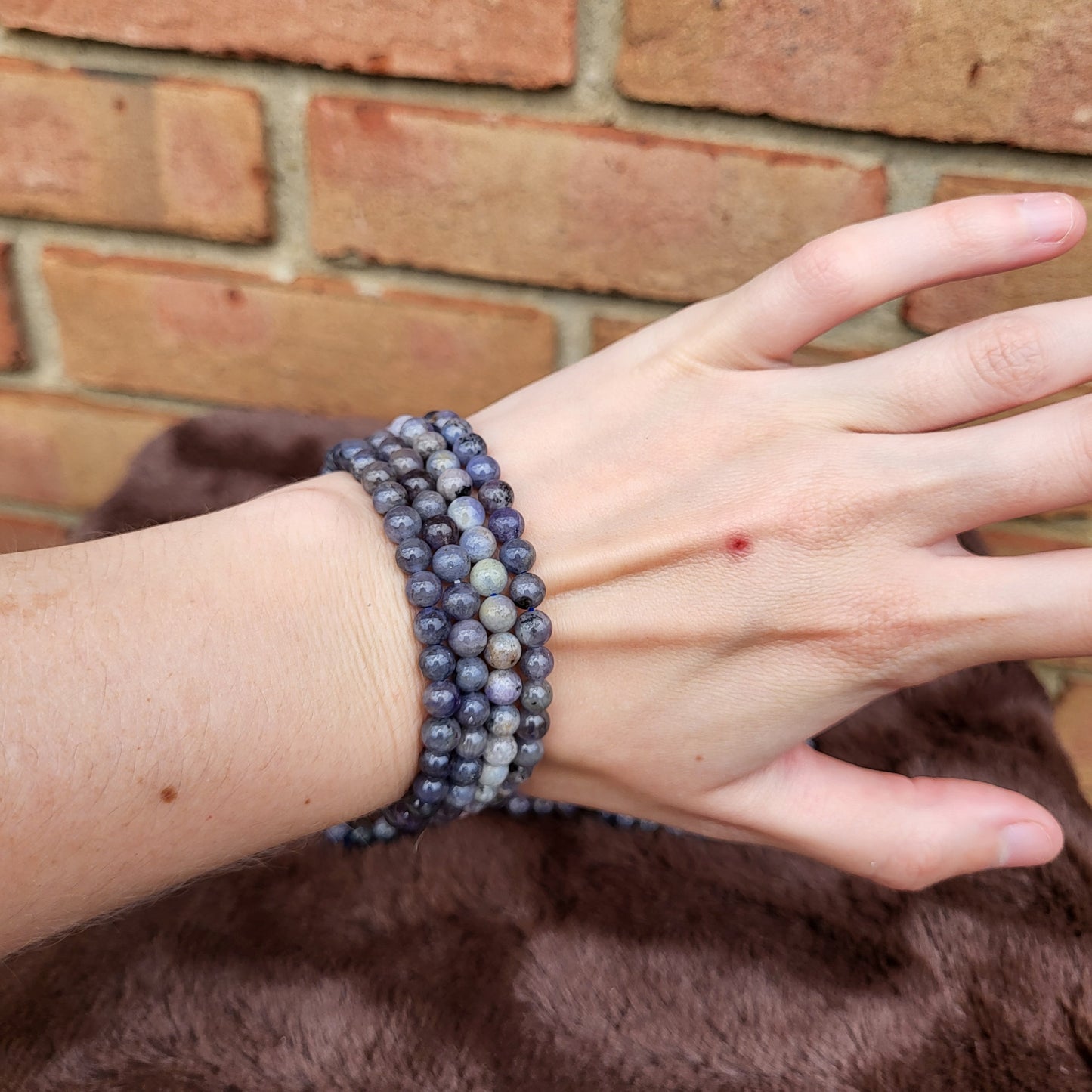 Elegant Tanzanite bracelet stacked on a hand showcasing unique shades of purple crystal