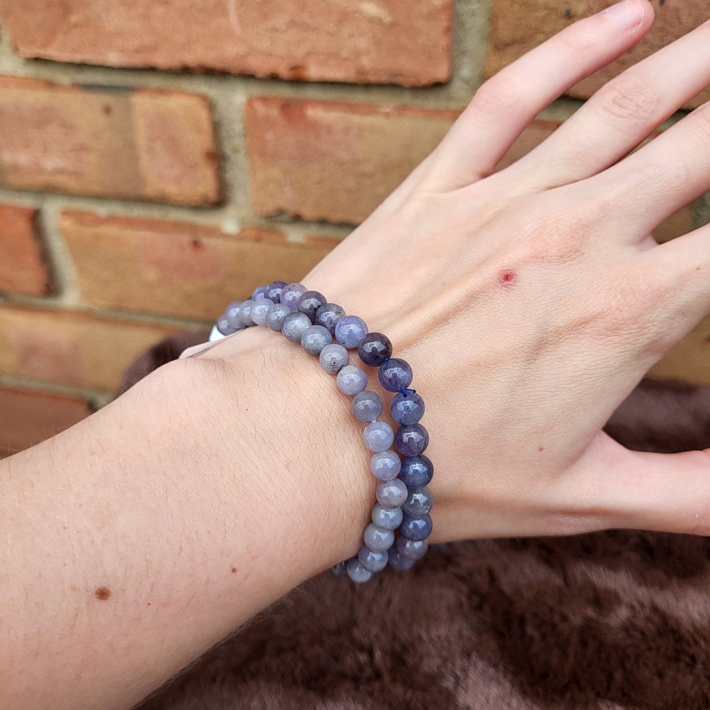 Tanzanite bracelet set displayed on a hand, showcasing beautiful purple hues and polished gemstones