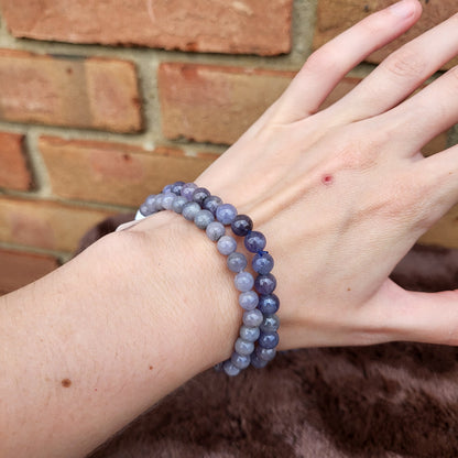 Tanzanite bracelet set displayed on a hand, showcasing beautiful purple hues and polished gemstones