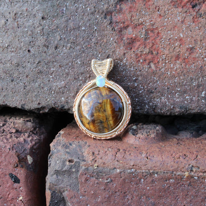 Tiger eye Etheopian Opal 14k yellow and rose gold fill pendant showcased on textured brick background