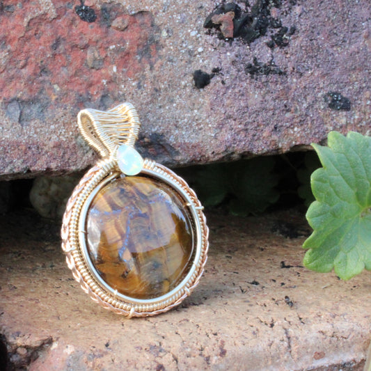 Tiger eye Ethiopian Opal 14k yellow and rose gold fill pendant wrapped in gold wire on rustic background