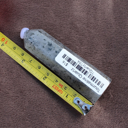Tourmalited Quartz Tower crystal measuring approximately 4 inches placed on a brown fabric background