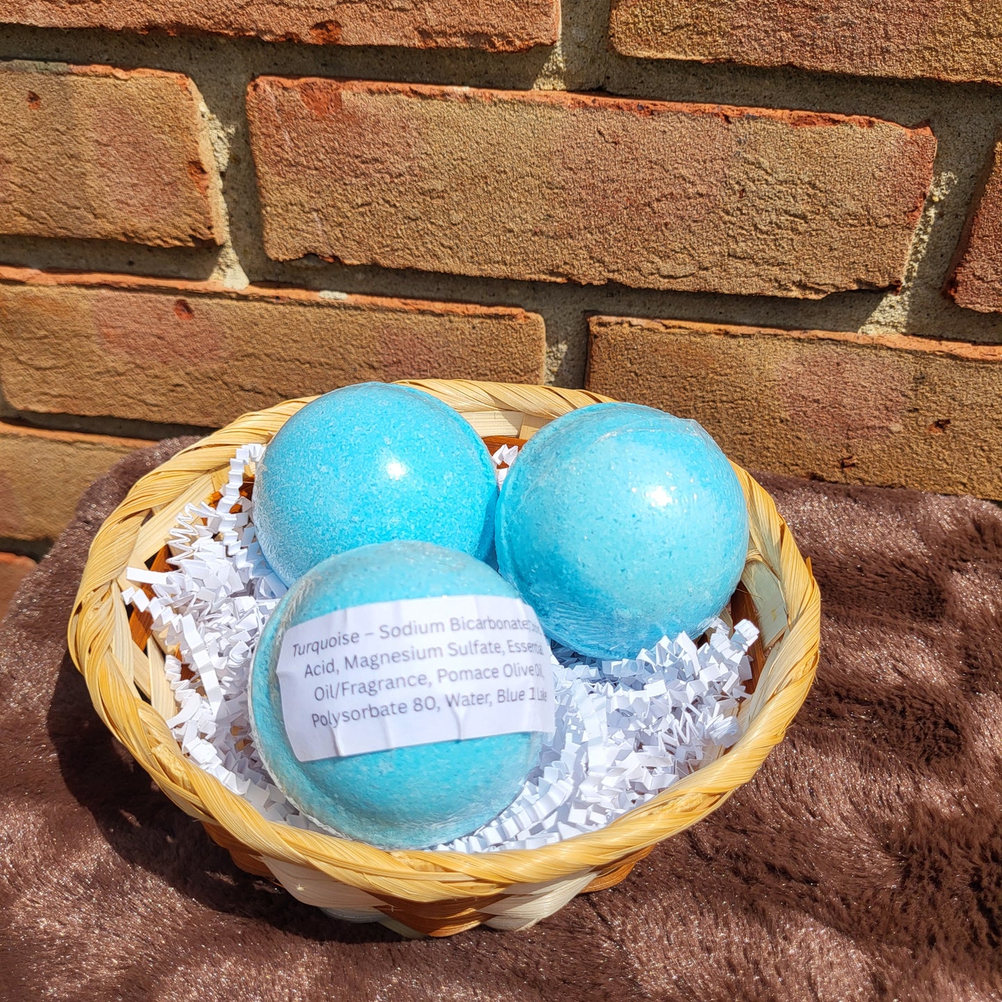 Three Turquoise Bath Bombs in a Basket with Shredded Paper Fill for Relaxing Bath Experiences