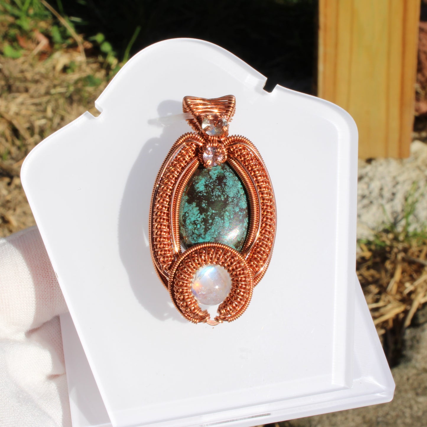 Turquoise copper pendant crafted with intricate wire detailing and a pearlescent stone